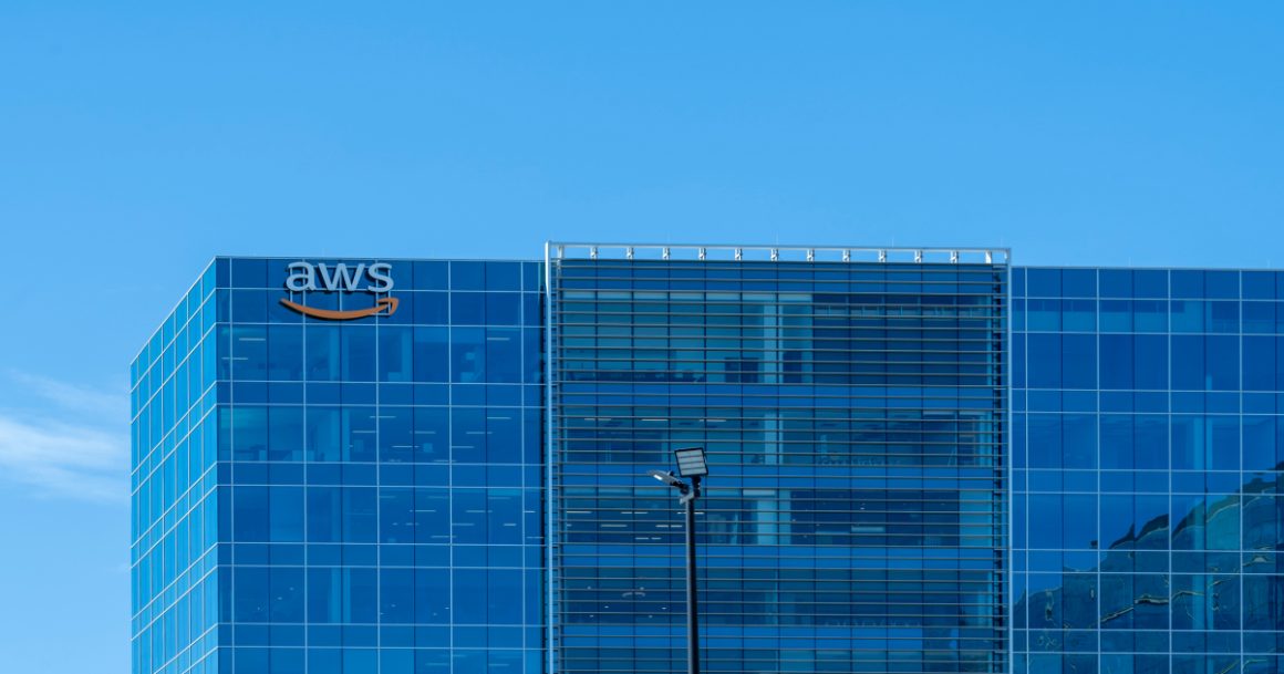 WS office building with the AWS logo on a glass skyscraper against a clear blue sky