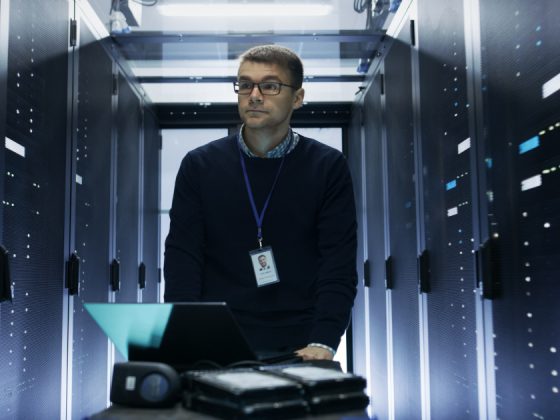 A data engineer walking through a server room data center in 2026
