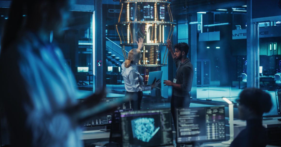Two quantum computing engineers discussing research in front of a large quantum processor in a high-tech laboratory