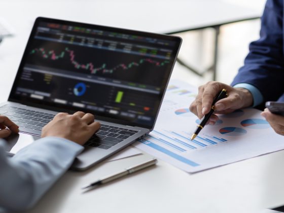 Two professionals collaborating on data analysis and machine learning metrics on a laptop during a business meeting.