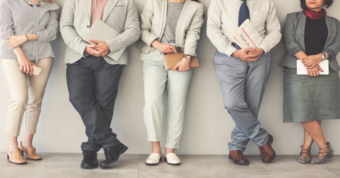 Group of people wearing modern interview outfits including blazers, neutral trousers, and formal shoes - examples of what to wear to a job interview