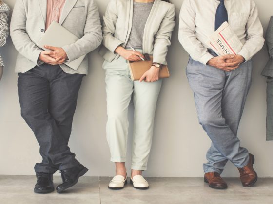 Group of people wearing modern interview outfits including blazers, neutral trousers, and formal shoes - examples of what to wear to a job interview