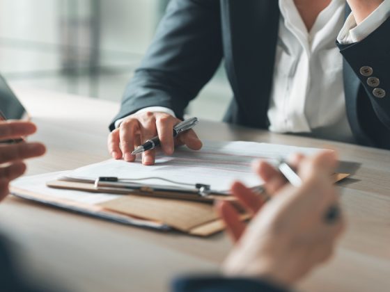 Interviewer and candidate reviewing documents across a desk during a job interview