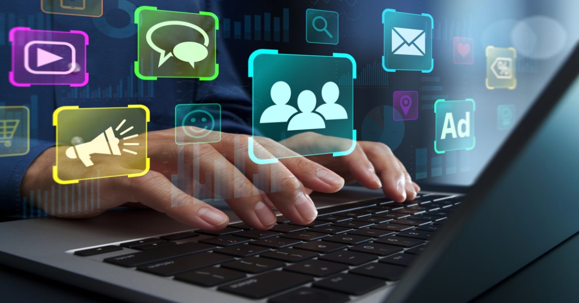 Hands on a laptop surrounded by digital marketing icons for email, ads, and social media.