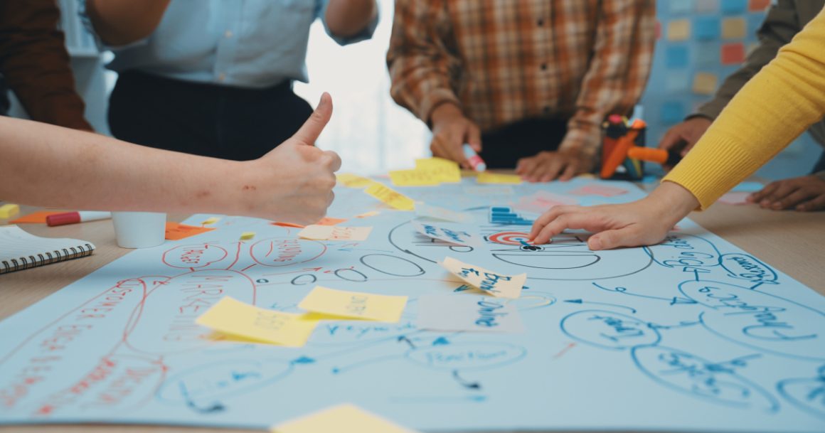 Team collaborating around a mind map with sticky notes and a target, illustrating problem-solving skills at work.