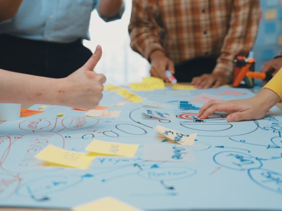 Team collaborating around a mind map with sticky notes and a target, illustrating problem-solving skills at work.