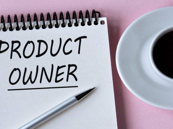 Product owner jobs concept with “Product Owner” handwritten on a notepad beside a cup of coffee.